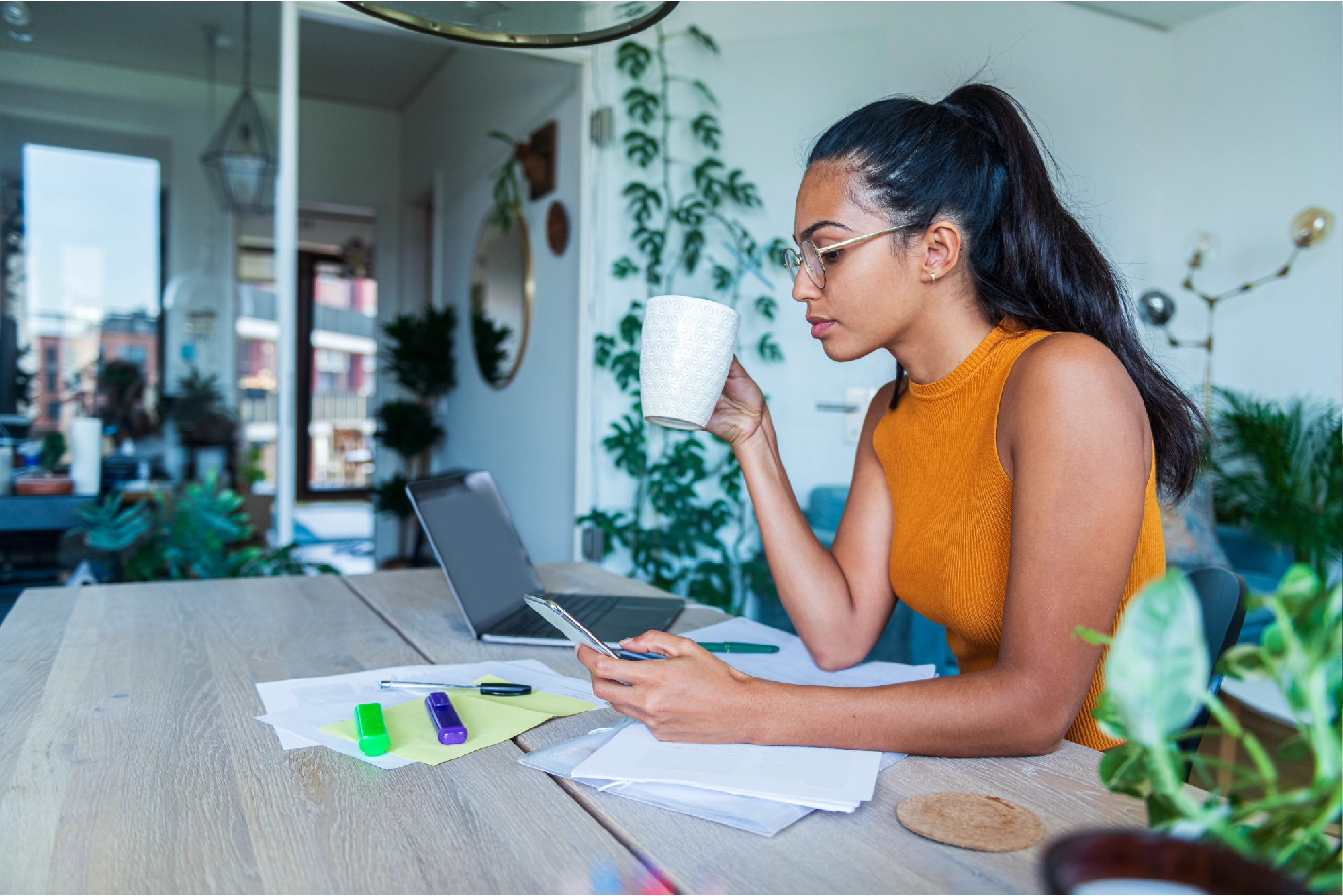woman sipping coffee while looking at laptop.